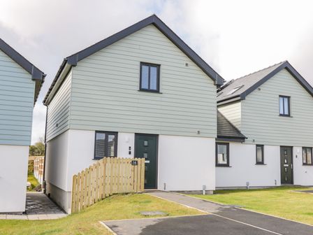 Front view of detached houses with pitched roofs and small fenced yards at 14 Parc Delfryn in Brynteg near Benllech