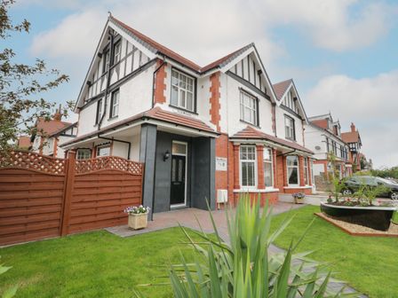 Exterior view of a semi detached house with front garden and driveway at 23 Carmen Sylva Road in Llandudno