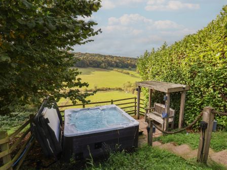 A hot tub beside a wooden bench at Kaitkyella Lodge in Scarborough