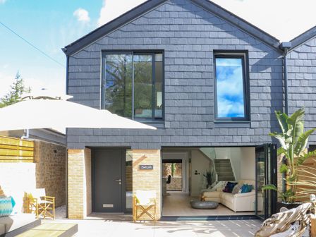 A house exterior with a patio area and open living room at Sail Loft in Dawlish