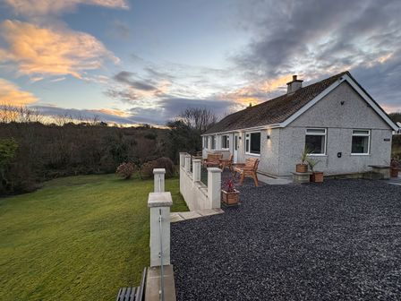 A house with benches and planters in the outdoor area at Caledfryn Benllech