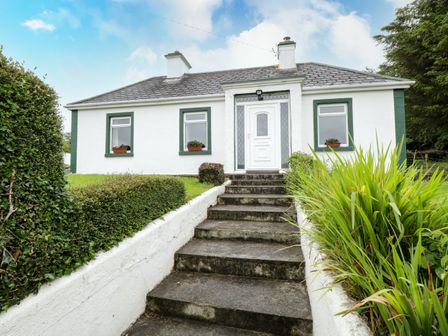 A white house with green window frames and a front door at Sean Bhaile in Glenisland near Castlebar County Mayo