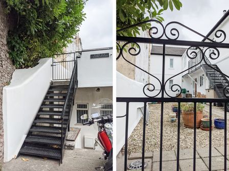 A black metal staircase and gate leading to white buildings with potted plants at 2 Chapelstones in St Marychurch Torquay
