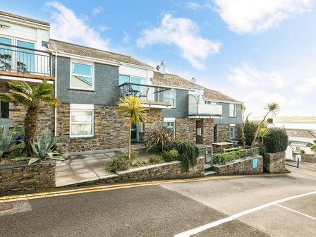 A stone and shingle exterior building with balconies and palm trees at Slipway 21 in Rock