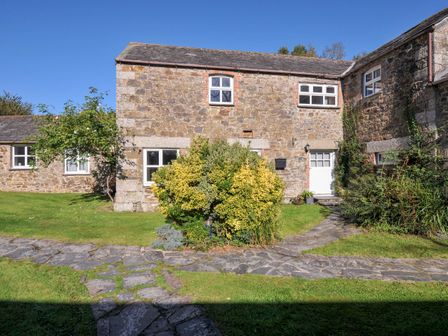 An outdoor view of a stone building with a pathway and garden at The Granary Rock