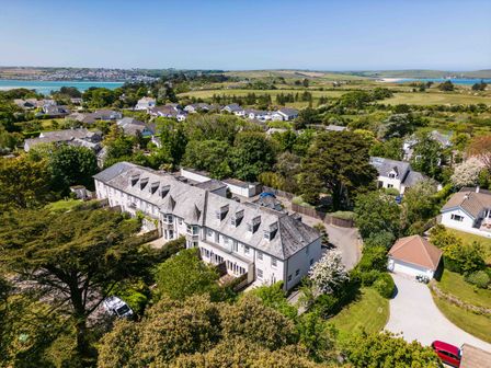 Aerial view of a residential area with houses trees and a body of water in the background at Lowenna Manor 10 Rock