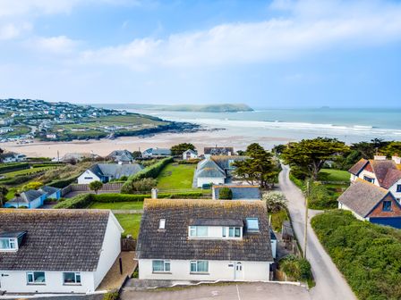 Houses near a beach with a road and trees at Bella Vista in Polzeath