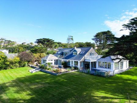 A house with a large lawn surrounded by trees at Greystones in Daymer Bay