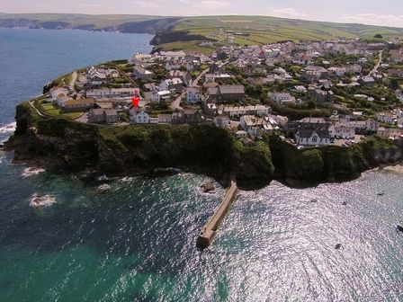 An aerial view of a coastal village with houses on cliffs next to the sea at Beehive Cottage in Port Isaac