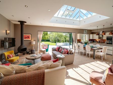 An open plan living area with sofas a dining table kitchen and a skylight at Trevanion in Rock