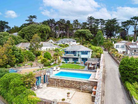 A house with a swimming pool surrounded by trees and a paved road at Camel Point in Rock