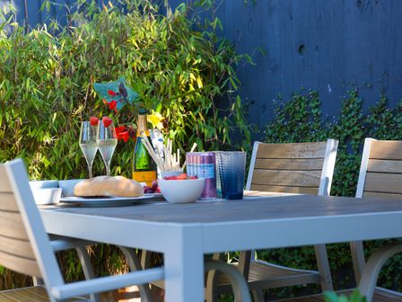 An outdoor dining table with chairs glasses champagne bread and fruit at Trengoff in Carbis Bay