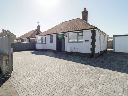 A single-story house with paved driveway and garage at Seaside Retreat in Prestatyn