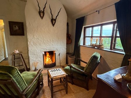 A living room with a fireplace and seating area at The Captain's Nest in Bunbeg, County Donegal