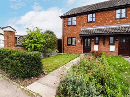 An exterior view of a brick house with a tiled roof and a garden with bushes and flowers at 1 The Gardens Old Newton near Haughley