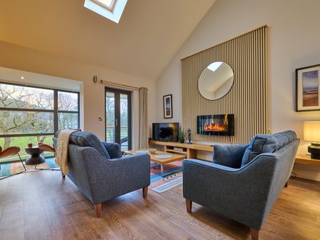A living room with a sofa and television at Riverside Park 5 in Keswick