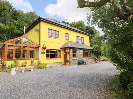 A house with a conservatory and garden at The Woodlands Lower Level in Stepaside