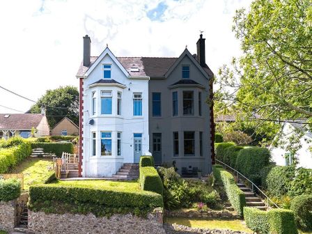 A semi detached two story house with a garden and shrubbery at Argoed in Abersoch