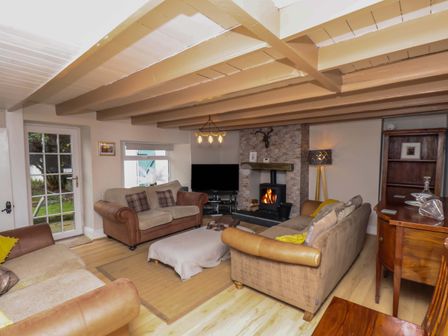 A living room with sofas a fireplace television and wooden furniture at Atlanta in High Hawsker near Whitby