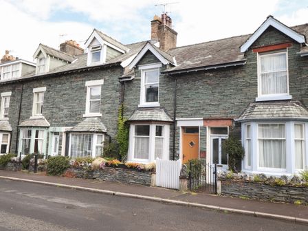 Row of stone terraced houses with front gardens and white framed windows at Dovestones in Keswick