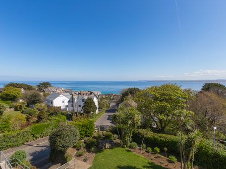 A coastal view with houses trees and a road leading to the sea at The Lighthouse in St Ives