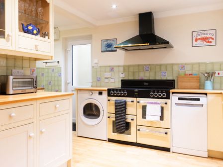 A kitchen with appliances including a microwave, oven, and washing machine at White Stones, Fulbrook, near Burford