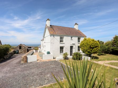 A white two chimney house with a tiled roof and garden at Congl Cae in Llangwnnadl near Aberdaron