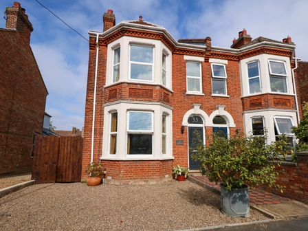 A brick semi detached house with bay windows and gravel driveway at Greylag in Hunstanton