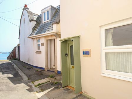 A narrow street with houses and a view of the water at Blanche Cottage Brewers Quay Harbour