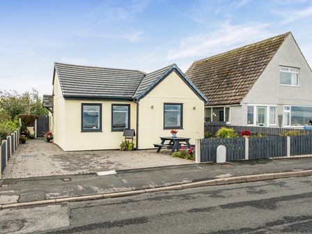 A house with a table and flowers near the entrance at Solway View in Skinburness near Silloth