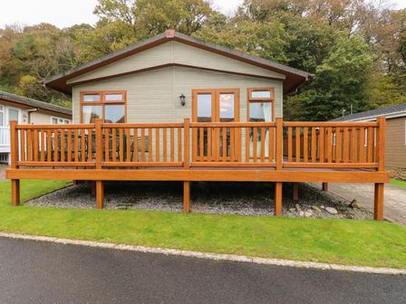 A single story house with a wooden deck and railing in front at 16 Heritage Park Heritage Park near Kilgetty