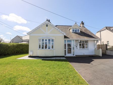 A detached house with a bay window and a driveway with grass lawn at Gwynant - Bull Bay in Bull Bay near Amlwch
