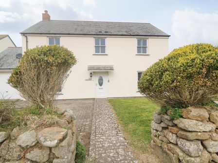 A two story house with a paved walkway and grass lawn at 15 Tower Meadows in St Buryan