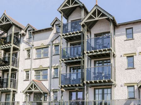 Exterior view of an apartment building with balconies and outdoor furniture at Claife Heights in Windermere