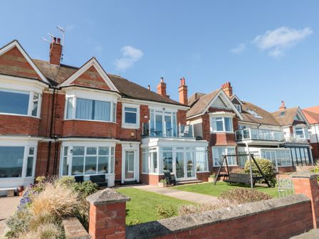 A row of brick houses with glass balconies and a garden swing at Crystal Cove in Bridlington