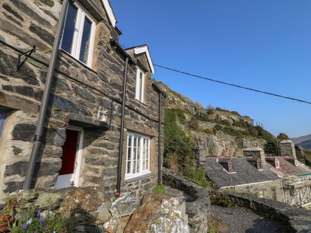 Stone cottages with slate roofs on a hillside with a clear sky at 2 Bwth Mawr in Barmouth