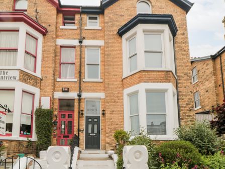 A brick terraced house with two entrances and bay windows at Spinnaker House in Scarborough