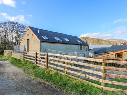 A building with a fence and pathway at Llofft Yr Yd Porthmadog