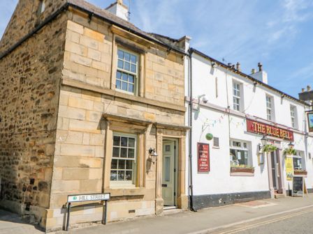 A street corner with stone and white buildings including The Blue Bell pub on Hill Street