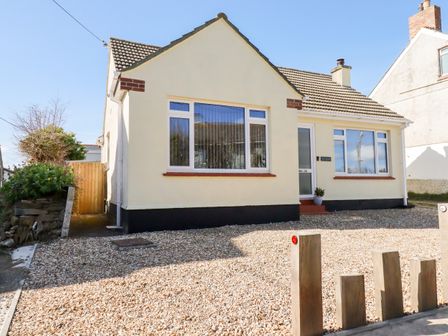 A detached house with a tiled roof and gravel driveway at Seawynds in Crantock