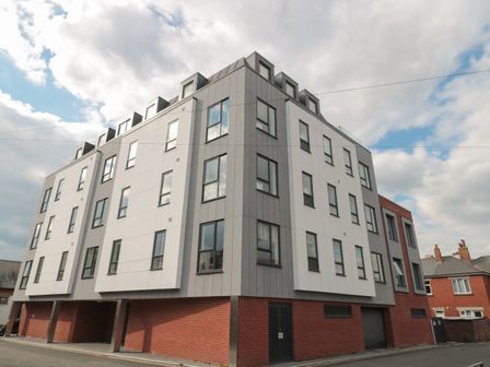 A multi story residential building with large windows and a brick base at Apartment 1 in Exmouth