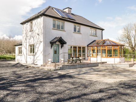A two-story house with a glass conservatory and gravel driveway at The Derries in Loughduff near Ballinagh County Cavan