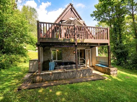 A house with a balcony and hot tub at Hideaway Cottage in St Ann's Chapel, Cornwall