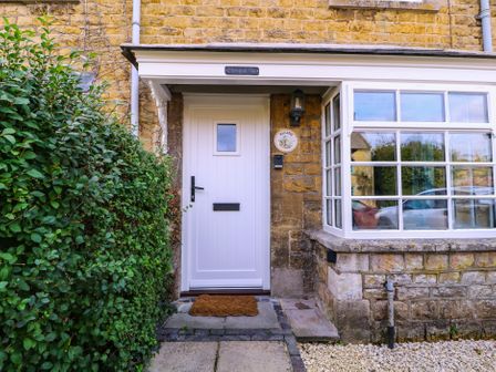 A front entrance with a door and window at Mallards in Bourton-On-The-Water