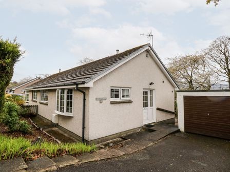 A single story house with a sloped roof and a garage next to it at Noble Knott in Keswick