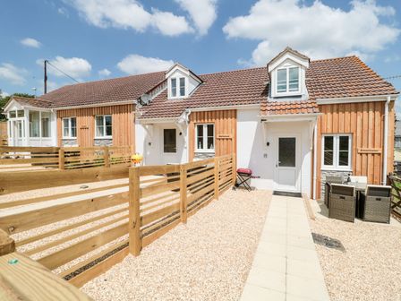 A row of cottages with wooden fences and outdoor furniture at Emminster in Nottington near Weymouth
