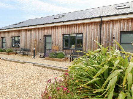 A building exterior with benches and gardens at Corvesgate Nottington near Weymouth