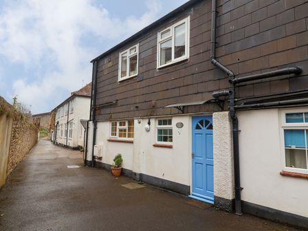 A street view of houses with a blue door and windows at Lyme Views in Lyme Regis