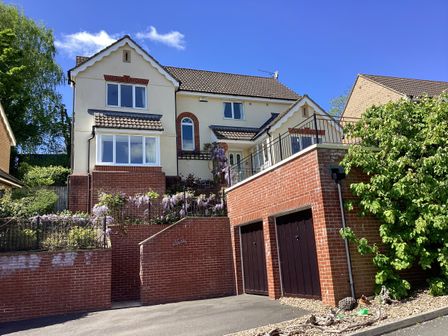 A two story house with a brick garage and garden in front at Jurassic Sea View in Lyme Regis