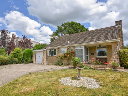 A bungalow with a garden and driveway in front at Byeways in Whitford
